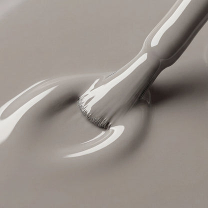 Gray paint being applied with a brush on a gray background