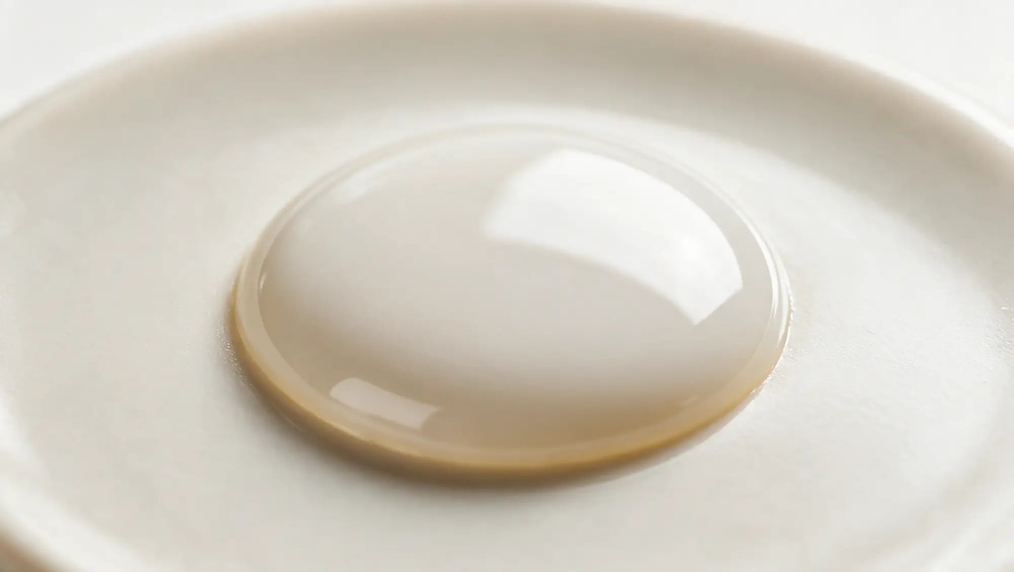 A pool of milky builder gel settled into a perfectly smooth dome